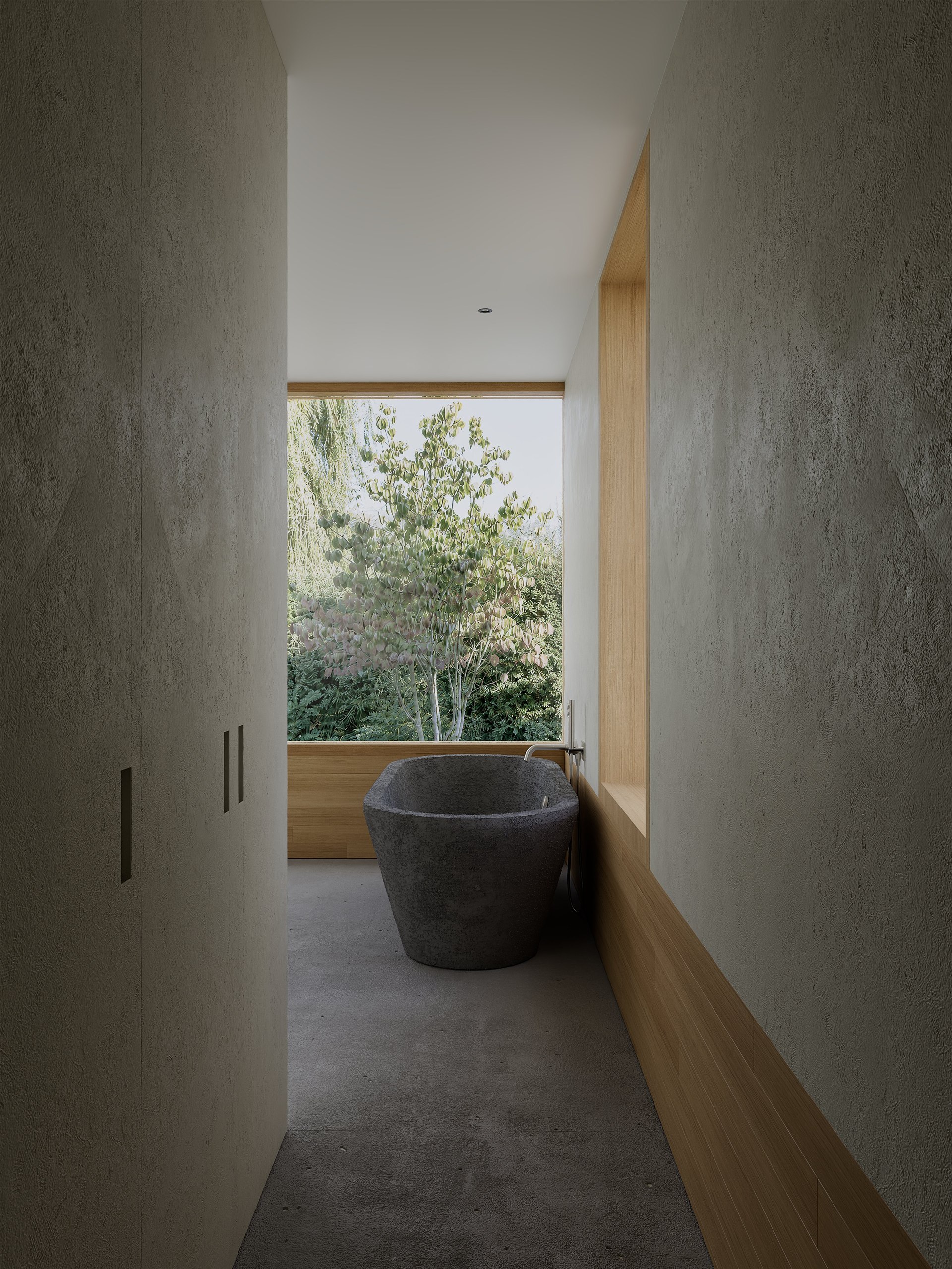 Sculptural stone bathtub in front of a full-height garden window